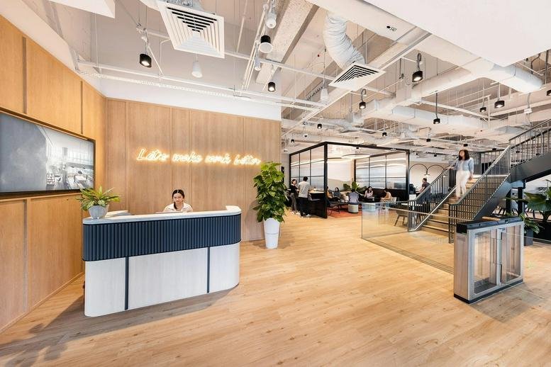 Modern reception at 9 North Buona Vista Drive, The Metropolis Tower One, with a wood-paneled wall and neon signage.