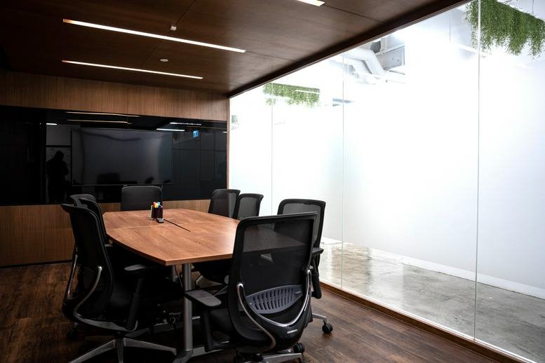 Wooden-paneled meeting room with a large table and ergonomic chairs at 5th Floor United Centre, 95 Queensway.
