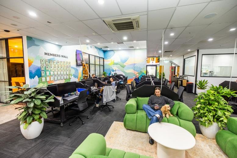Spacious communal lounge at 95B Station Street, Level 1, Penrith, Sydney featuring green sofas and mural walls.