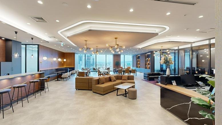 Spacious communal lounge with diverse seating, warm lighting, and city views at 9F-10F, 3-chome Umeda.