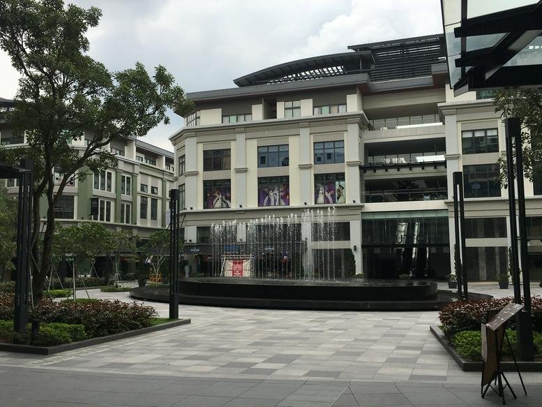 Exterior view of the contemporary facade and courtyard at Block Anson, Plaza Arkadia.