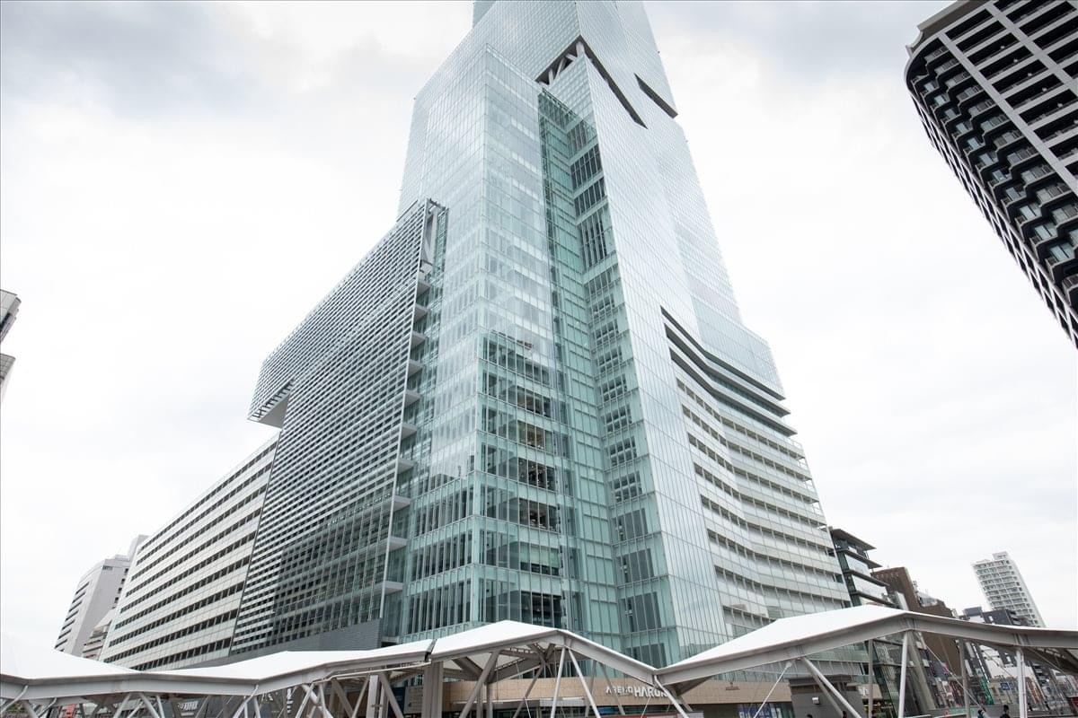 Exterior view of the glass-facade Abeno Haruks skyscraper reaching into the clouds.