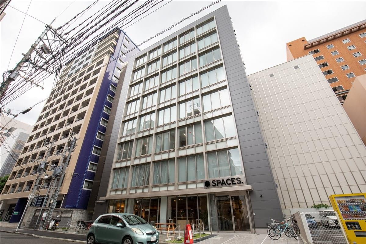 Exterior view of the glass-facade Spaces building at 3-4-25 Hakataekimae.