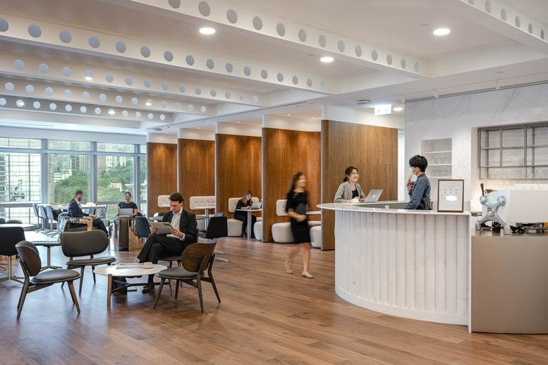 Spacious reception and lounge at AIA Central with wooden booths and warm lighting.
