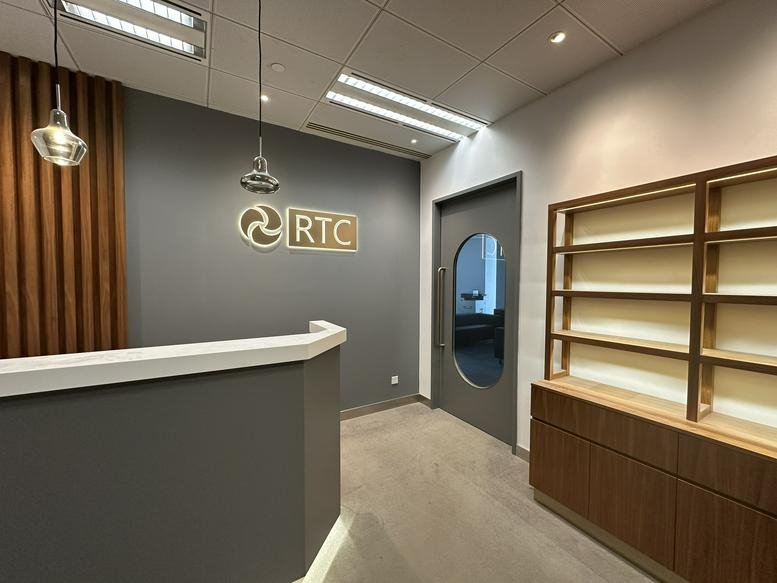Branded reception area at AIA Kowloon Tower, Landmark East with a sleek grey desk and wooden accents.