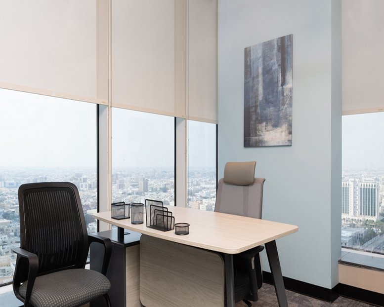 Private office with two mesh chairs and a desk overlooking the city from Balhamar Business Tower.