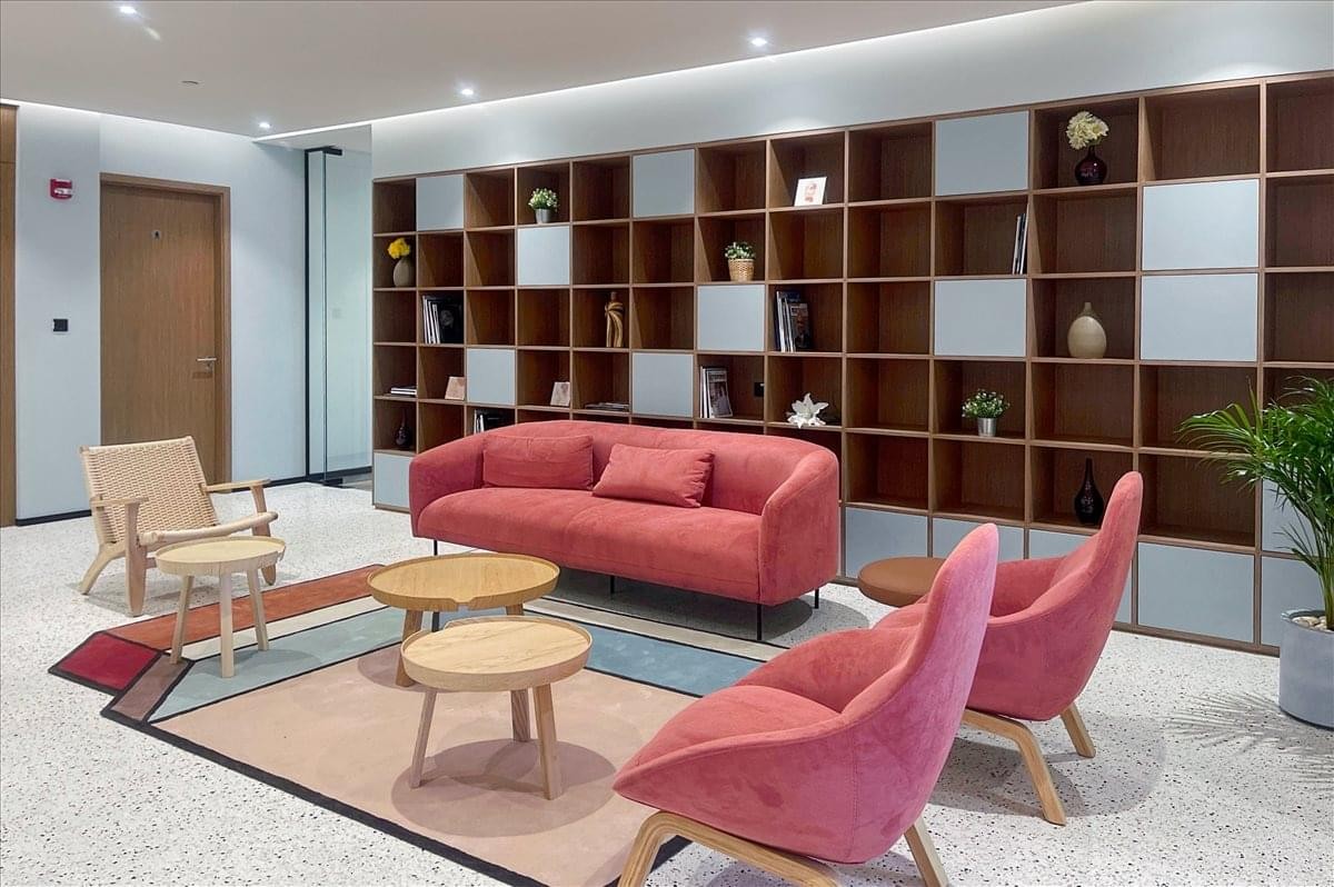 Main reception desk at Al Maqam Tower featuring terrazzo stone and wood paneling.
