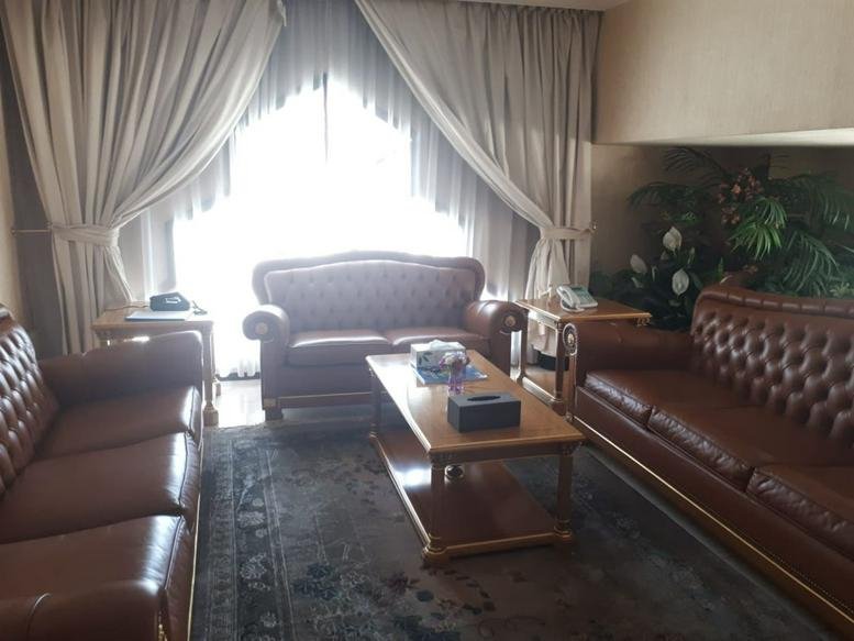 Classic lounge area at Al Nasr Street, Abu Dhabi featuring brown tufted leather sofas and a wooden coffee table.