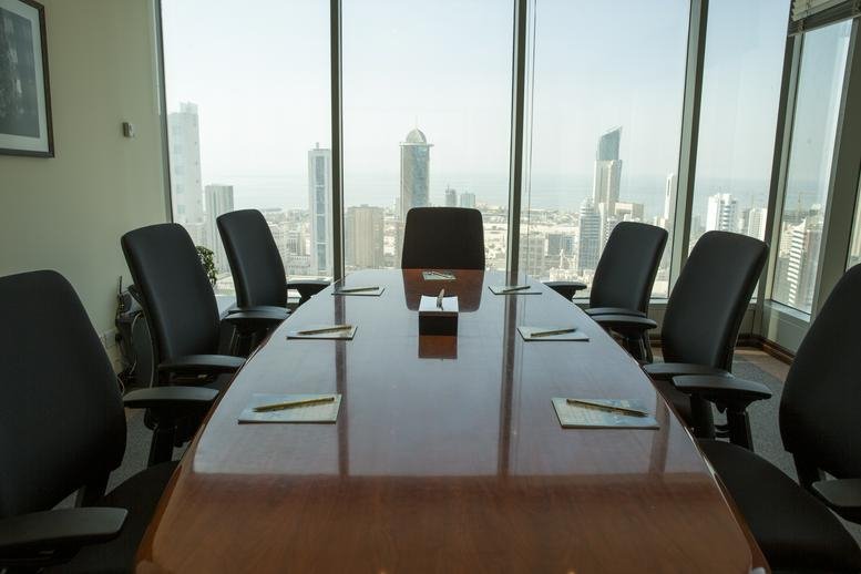 Polished conference table with black chairs overlooking an urban skyline.
