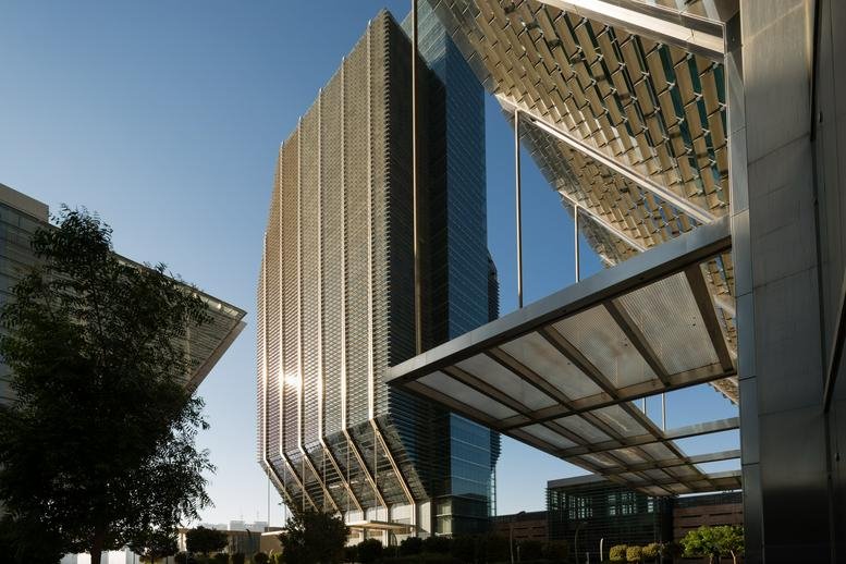 Exterior view of the glass and steel facade of Al Sila Tower with a modern geometric canopy.