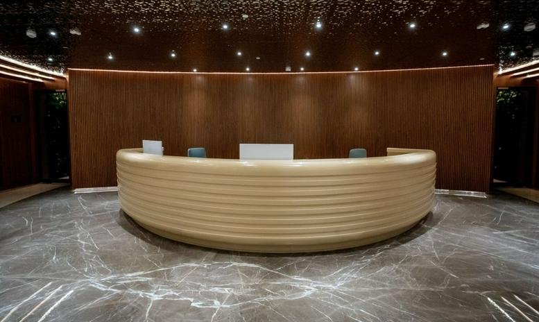 Spacious lobby featuring a large, curved reception desk at Aldar HQ in Al Raha Beach.