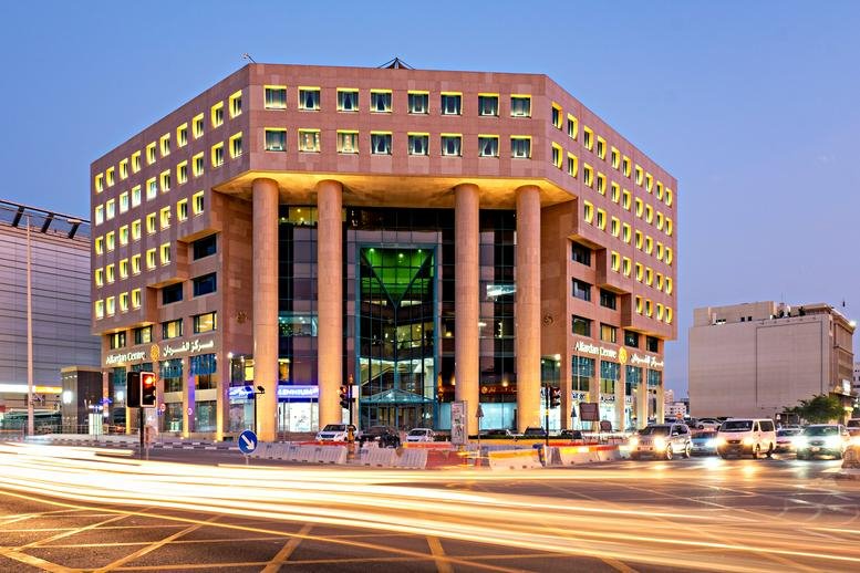 Exterior view of the grand, geometric Alfardan Centre Building at sunset.