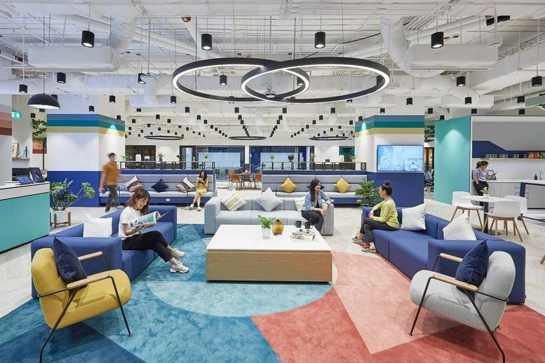 Vibrant lounge area with colorful rugs, blue sofas, and circular pendant lighting.