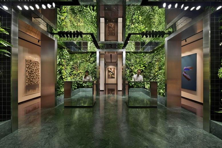 Modern lobby at Asia Square Tower 2 with vibrant green living walls and polished stone floors.
