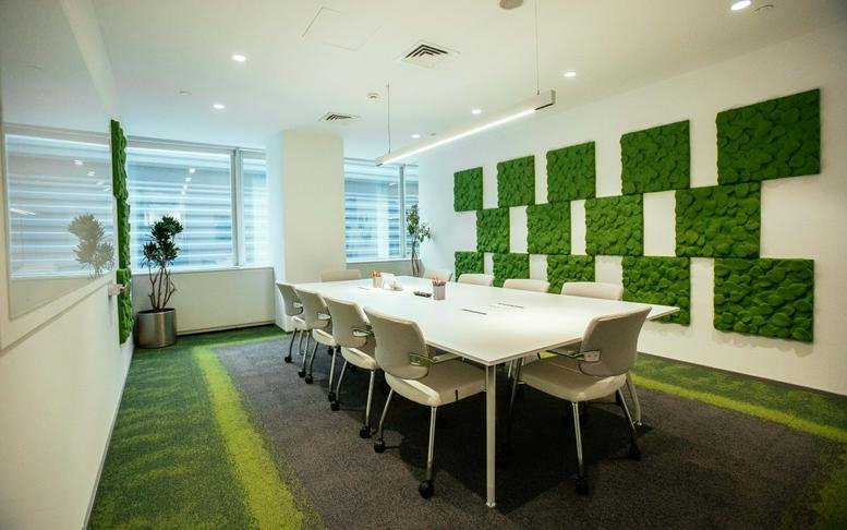 Spacious boardroom at Büyükdere Cd. No: 173, Istanbul featuring a green moss feature wall and white table.