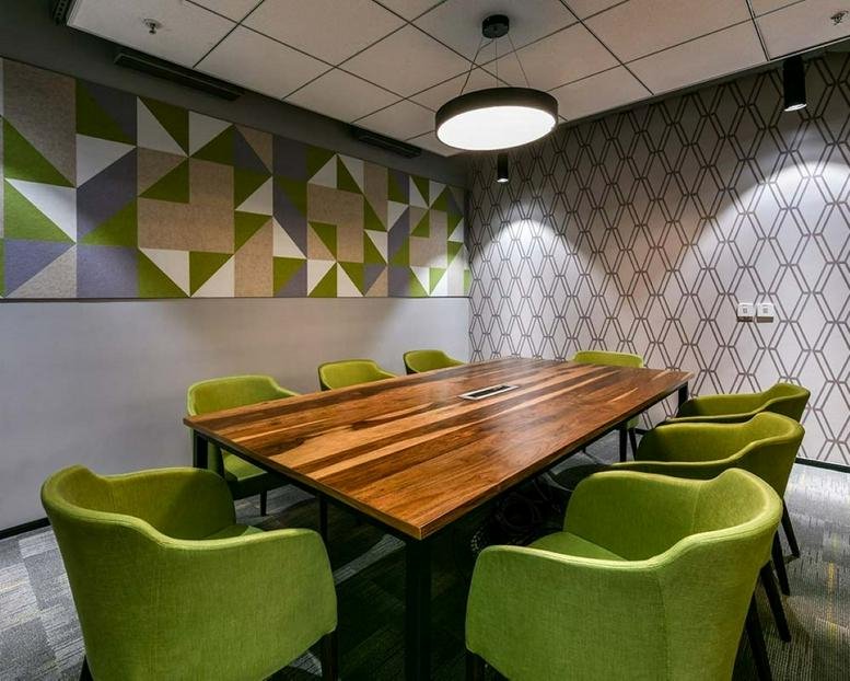 Meeting room at Bascon Futura SV IT Park with lime green chairs and a natural wood table.