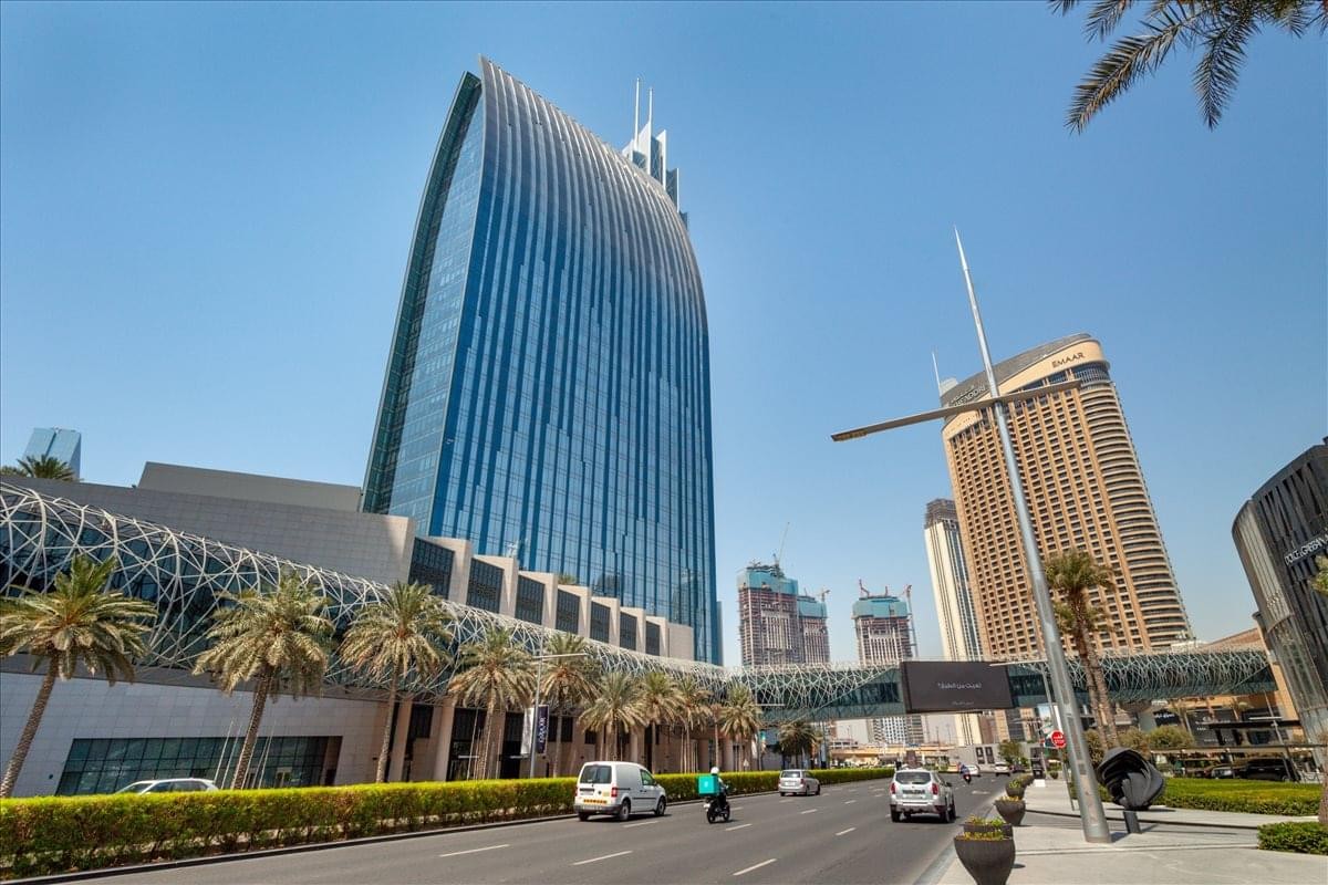 The sleek, curved glass exterior of Boulevard Plaza, Tower 1 under a clear blue sky.