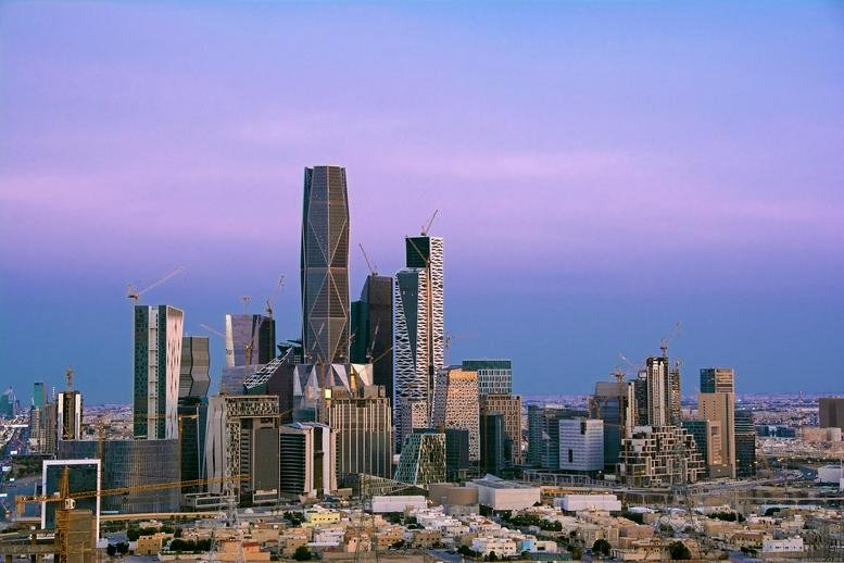 Exterior view of the skyscrapers including Building 1.15 at Al Aqiq under a purple dusk sky.