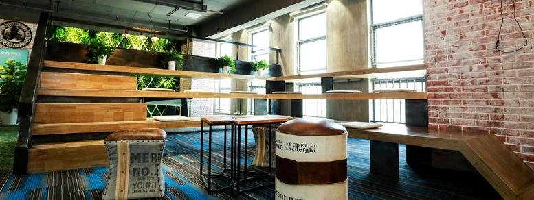 Spacious communal lounge at Building 5, Dangdai Science and Technology Park with tiered wooden seating and brick walls.