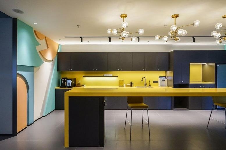 Modern communal kitchen at Building 7, Wanxianghui with a long yellow island table and designer lighting.