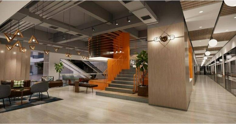 Spacious lobby area with a large staircase and modern lounge seating.