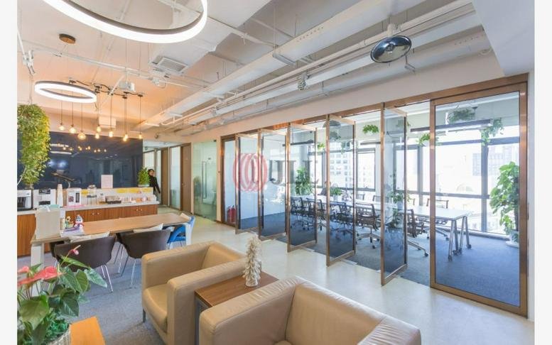 Spacious open-plan common area at Building B, U-Town International with modern seating and glass-walled meeting rooms.