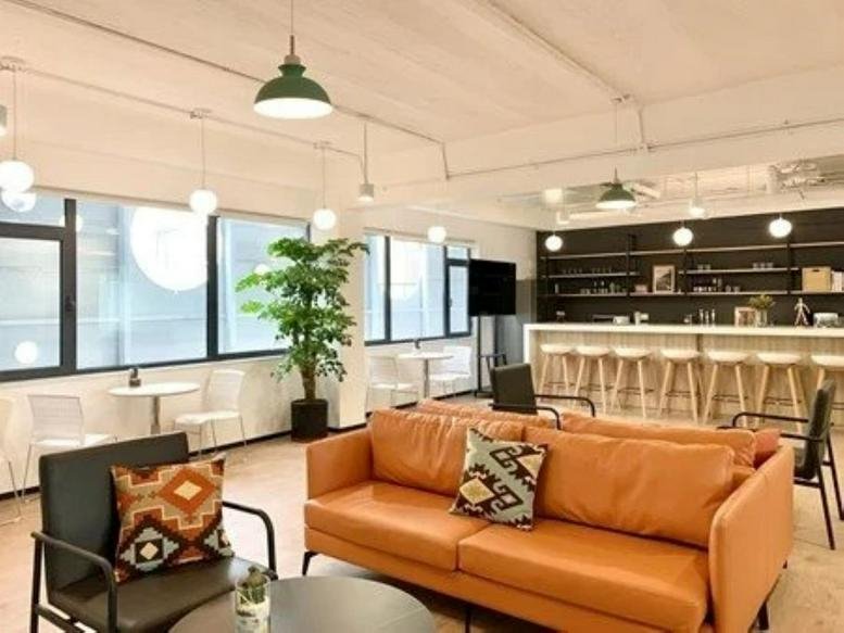 Spacious communal lounge at Building D, China Stone with an orange sofa, indoor plants, and a bar area.