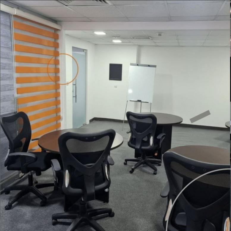 Collaborative meeting room at Ground Floor, Housing Bank Complex, with round tables and mesh chairs.