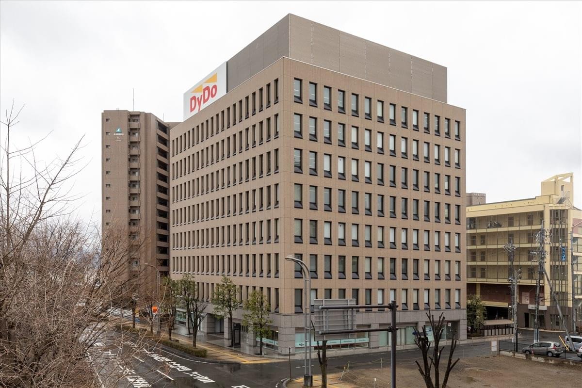 Full exterior view of the multi-story Choei Nagano Higashiguchi Building 1･2F under an overcast sky.
