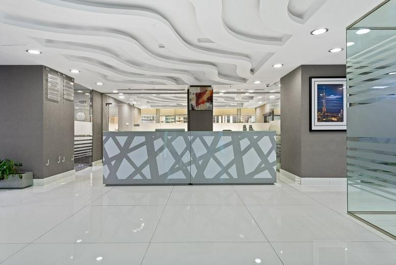 Reception area at Clover Bay Tower with a modern patterned desk and a wavy feature ceiling.