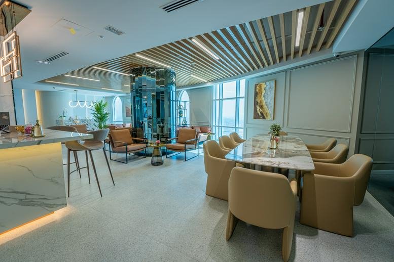 Spacious communal lounge at Cluster N with a marble dining table and leather armchairs.