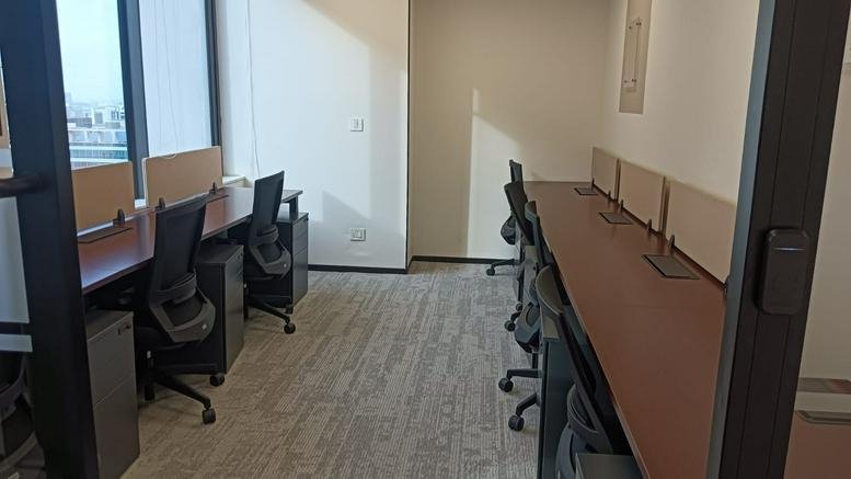 Modern reception area with a curved white desk and wood-paneled feature wall at Offix Commerzone Hyderabad.