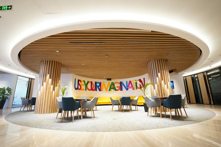 Wide-angle view of District Building B office lobby with creative wood-slat pillars.