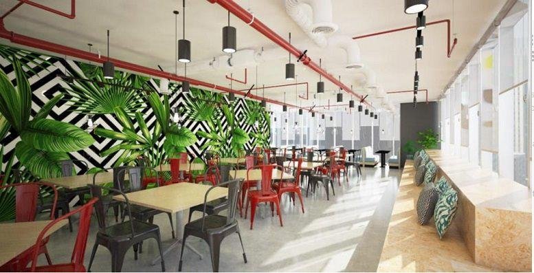 Colorful dining area at Festive Walk Office Tower 1 with green leaf-patterned walls and hanging industrial lights.