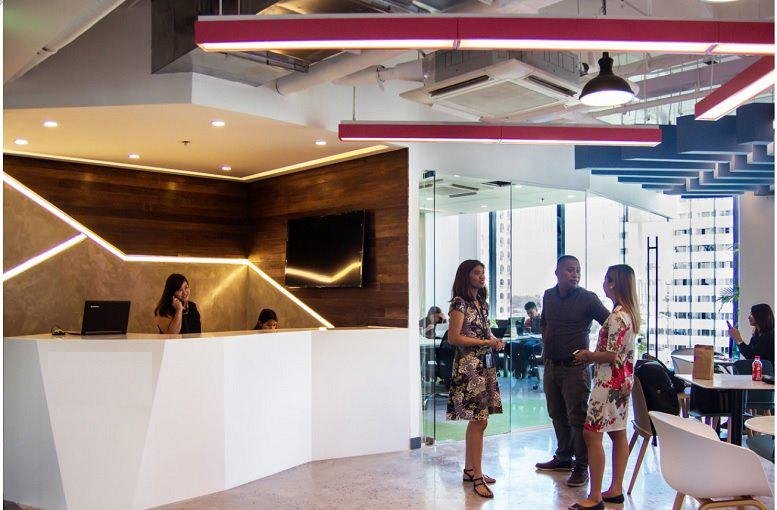Modern reception area at One Griffinstone Building with a white geometric desk and warm wood feature wall.