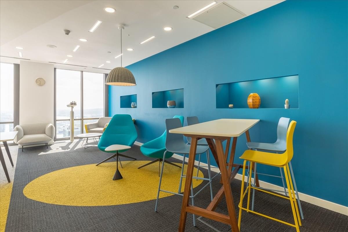 Colorful breakout area at Fukuoka Daimyo Garden City Tower with blue feature walls and a yellow rug.