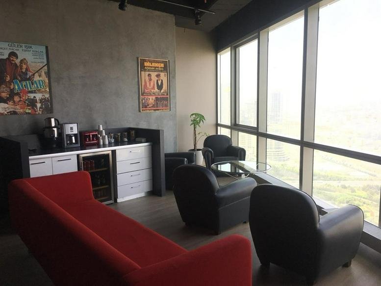 Lounge area with a red sofa and city views at Ofisim Kayseri B Blok Kocasinan.