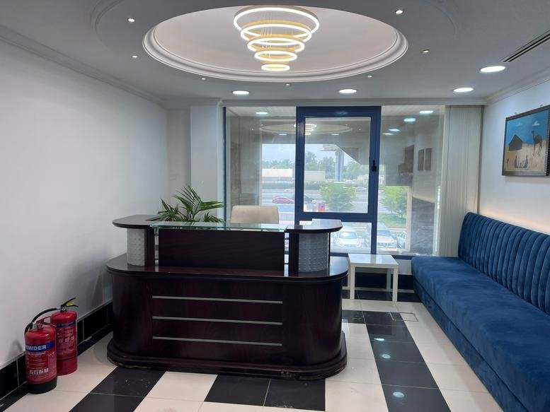 Modern reception lobby at Golf Park Building, Al Garhoud, M Floor, Dubai with a wood desk and blue velvet sofa.