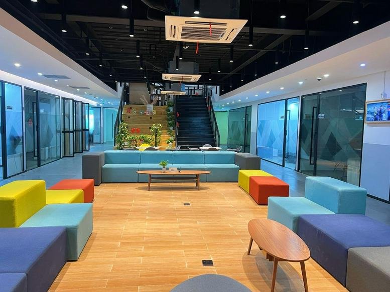 Spacious, modern lobby at Guangfu United International Center with colorful modular seating and a central staircase.
