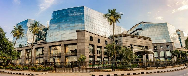 Exterior view of the modern glass-facade building at HAL Old Airport Road, Domlur, Bangalore.