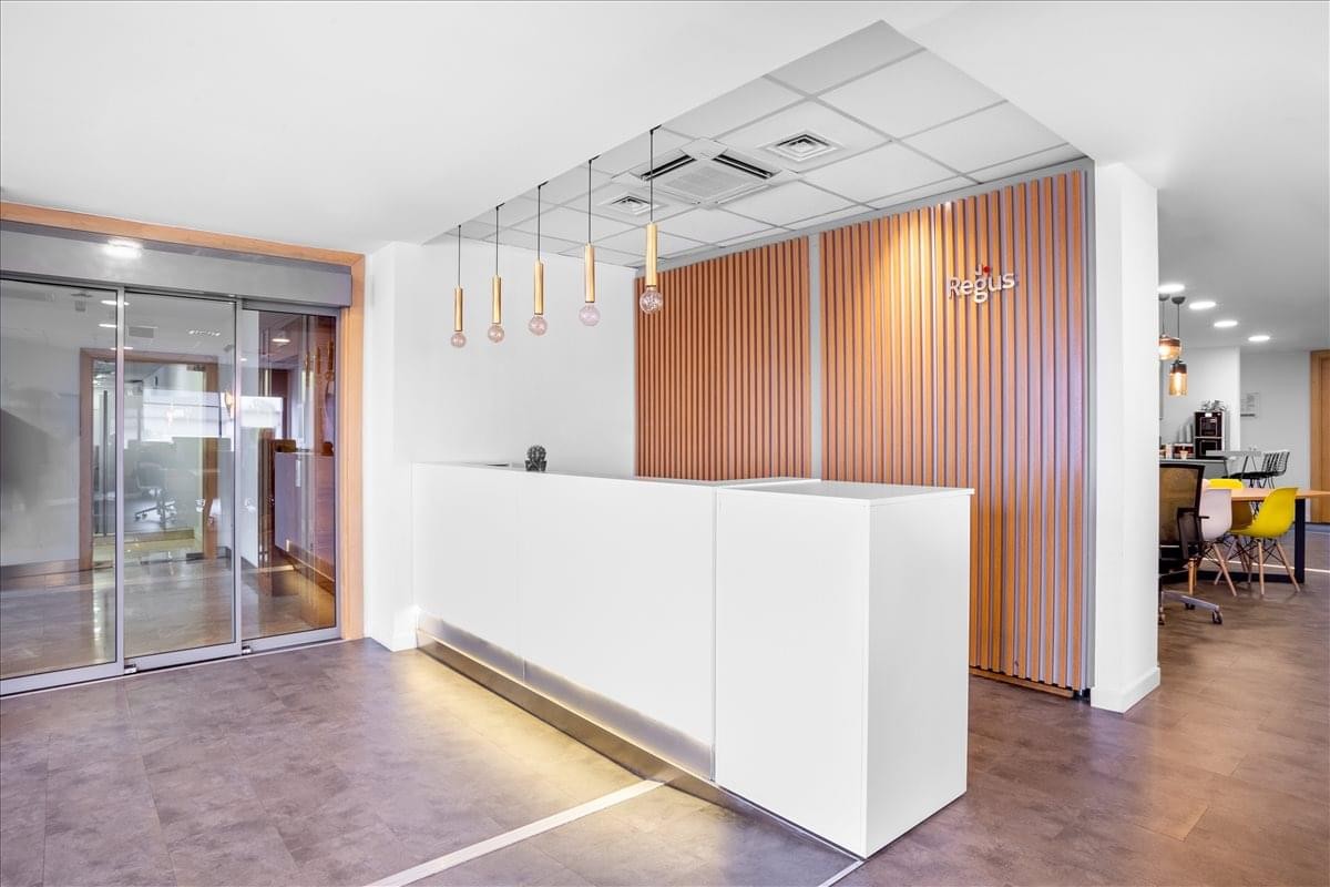 Bright reception area featuring a white desk and wood-slatted feature wall.