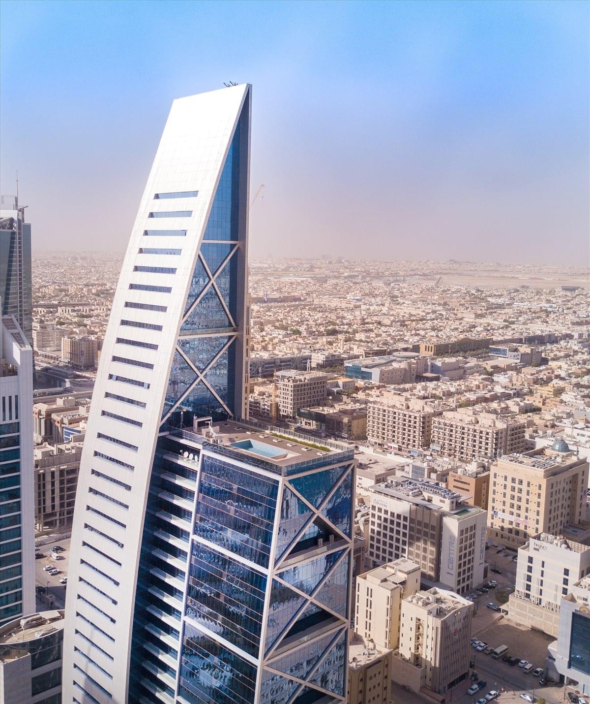 Exterior view of the striking sail-shaped facade of Hamad Tower against a clear sky.