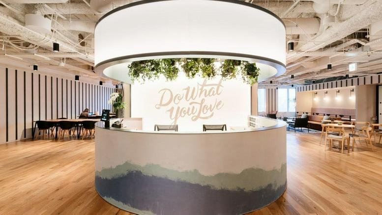 Wide-angle view of the bright, circular reception desk at Hanzomon PREX with a neon Do What You Love sign.