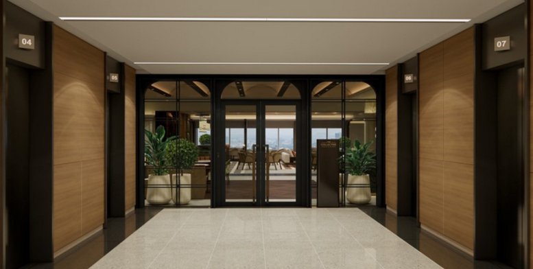 Symmetrical elevator lobby at Helios Business Park Tower D with wood paneling and glass doors.