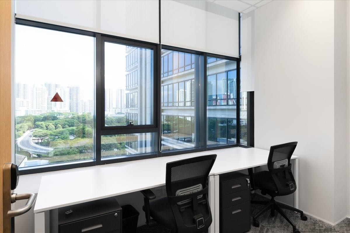 Private office with two desks and a large window overlooking the city at Hiap Hoe Building.