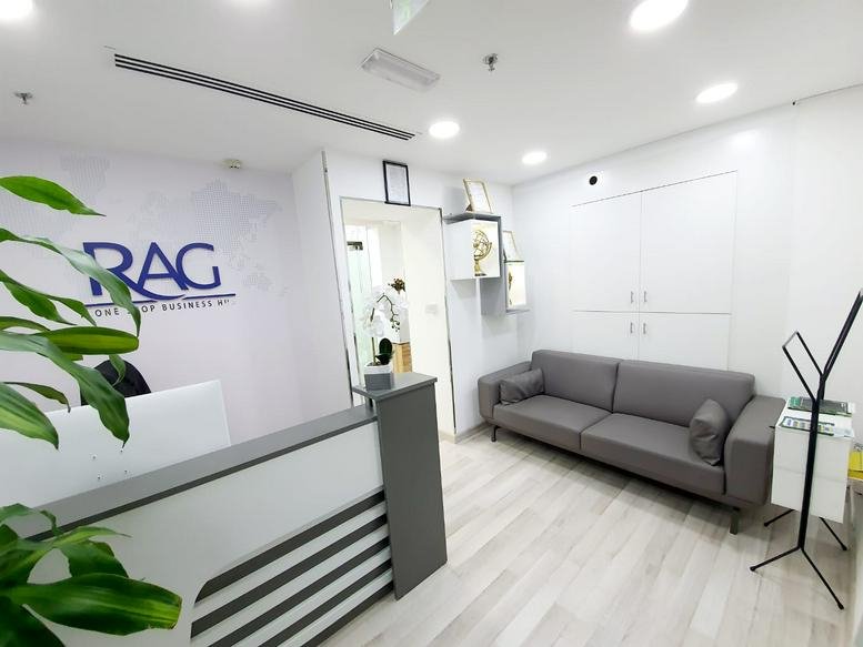 Reception area of the Hilal Bank Building featuring a grey sofa and branded desk.