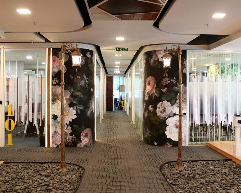 Symmetrical corridor at Western Aqua, HITEC City, Hyderabad, India featuring floral murals and vintage street lamps.