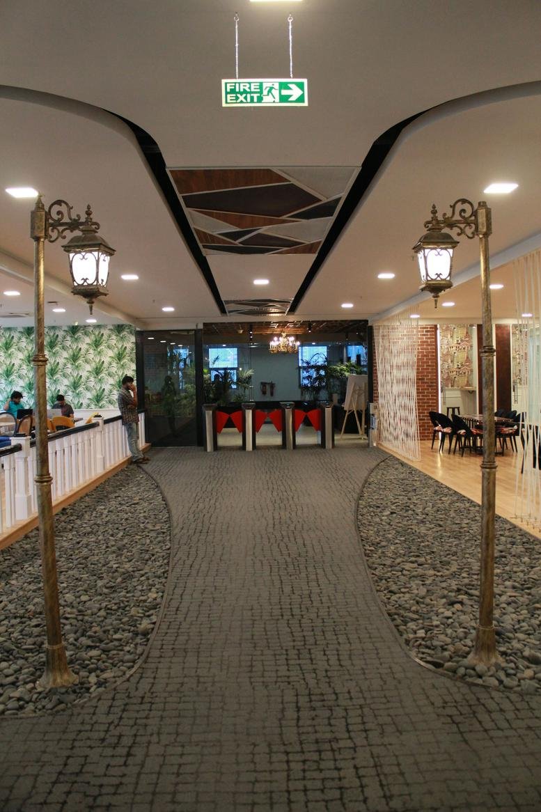 Spacious lobby at Western Aqua, HITEC City, Hyderabad, India featuring a stone path and street lamps.
