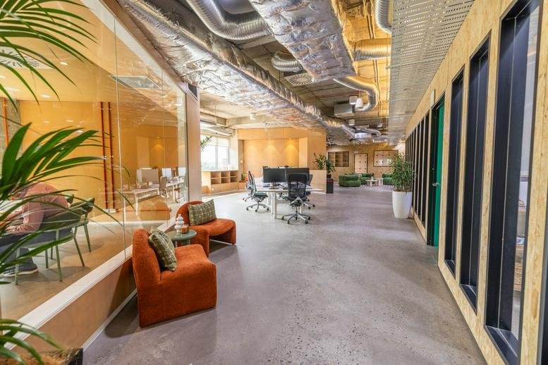 Spacious reception area with orange velvet armchairs and exposed ductwork at Level 3/1C, Homebush Bay Drive.