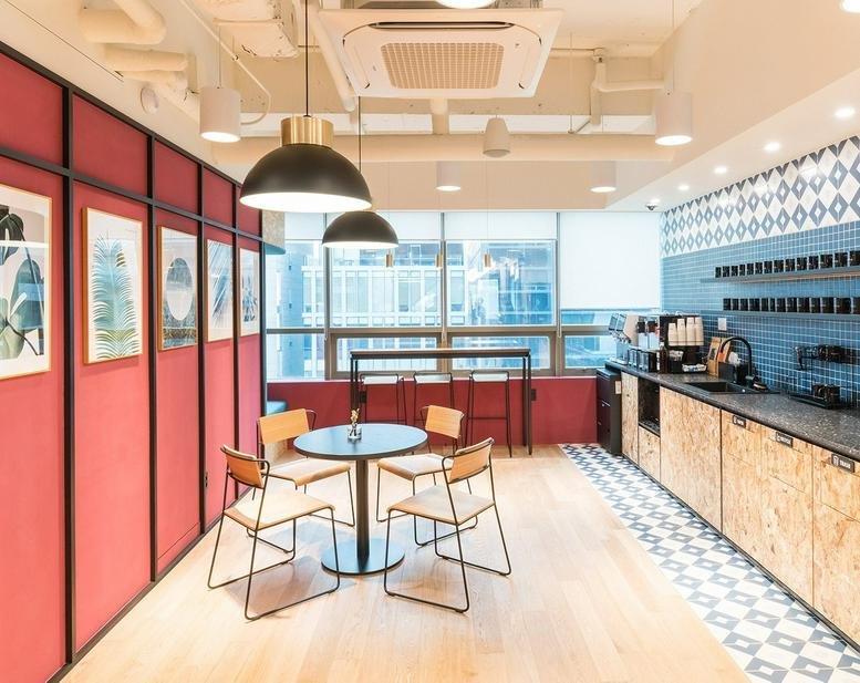 Spacious communal dining area with red paneled walls and a small cafe-style table at Hongdae 1st store, 161 Yanghwa-ro.